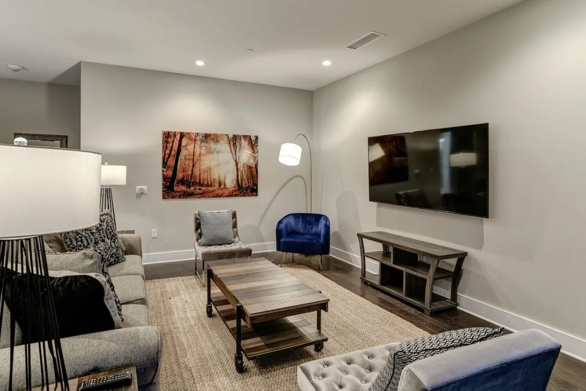 A stylish living area with a contemporary sofa, coffee table, wall art, and a large window that brings in natural light. The space feels open and inviting, ideal for relaxing after city adventures.